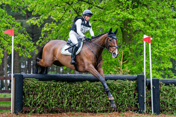 Horse and rider jumping over an obstacle in an equestrian competition.