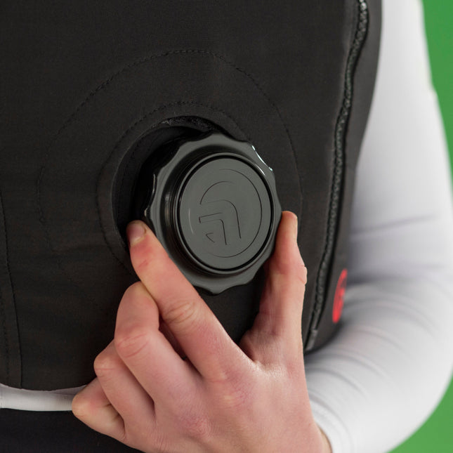 Person adjusting a black body protector with a button on a green background