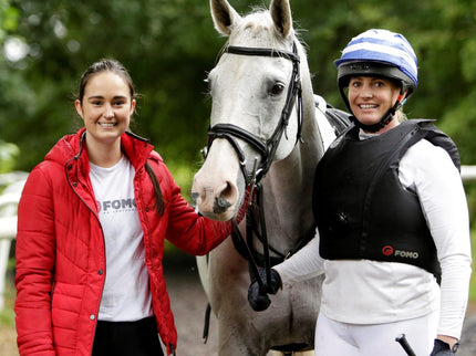 Two women with a horse in an outdoor setting