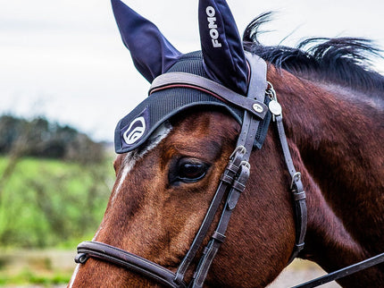 Horse wearing afly veil with a visible brand logo in an outdoor setting
