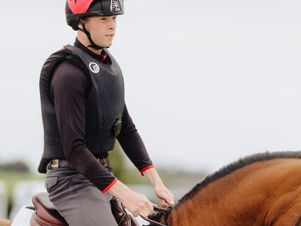 Person riding a horse in equestrian attire with a blurred background