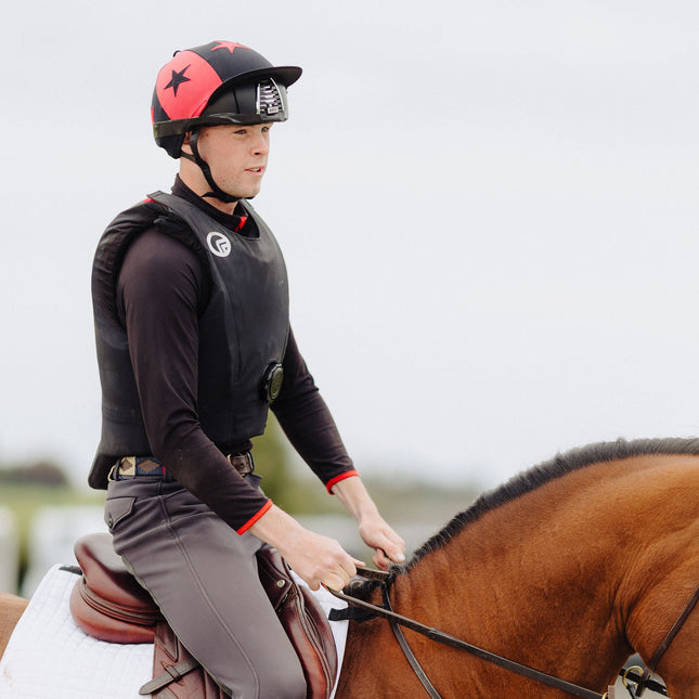 Person riding a horse in equestrian attire with a blurred background