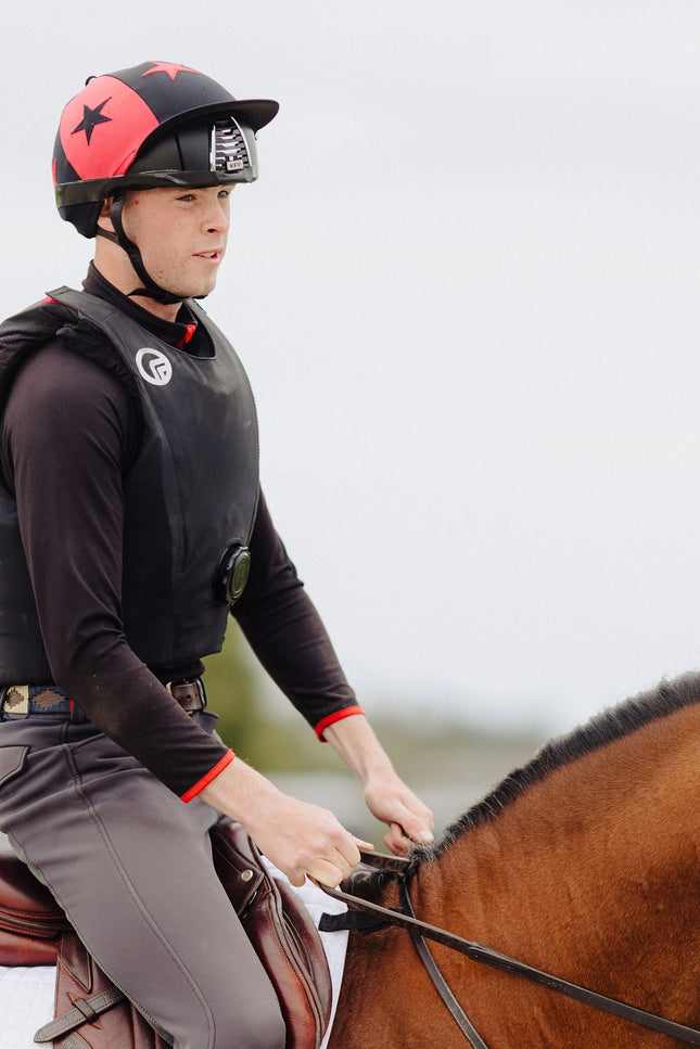 Person riding a horse in equestrian attire with a blurred background